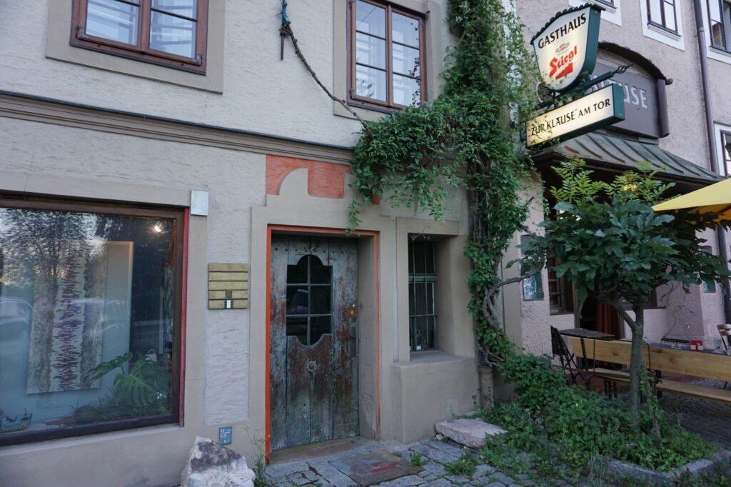 Modest guesthouse entrance in a small hill town in the early evening with warm exterior lighting