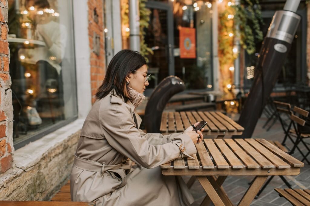 Person reading profiles on a smartphone in a cafe in the evening