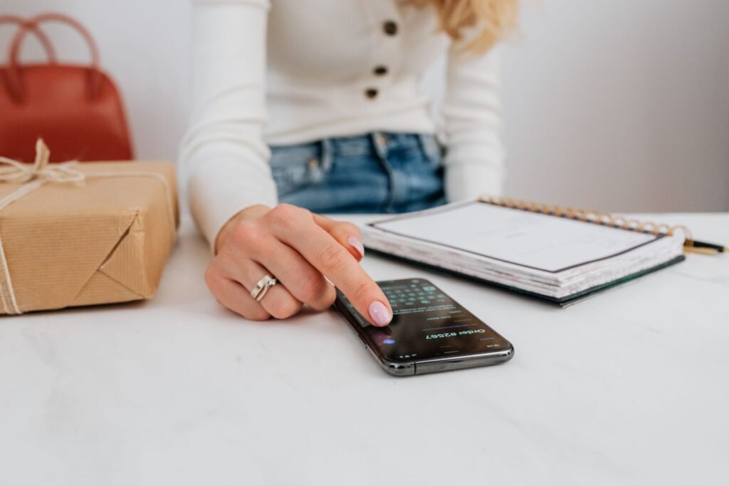 Person writing a short evening plan in a notebook beside a phone