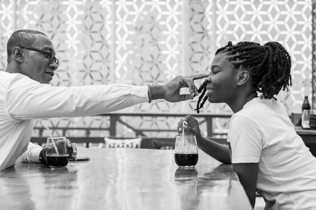 Two adults in respectful conversation at an outdoor table in Ghana