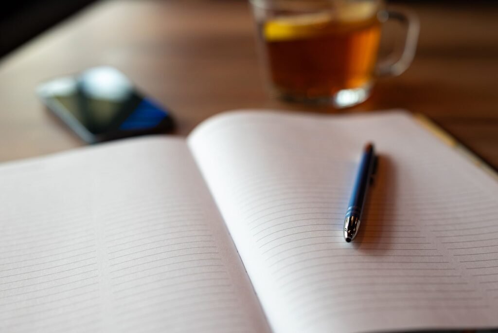 Smartphone and notebook on a wooden table with tea, representing safe online communication