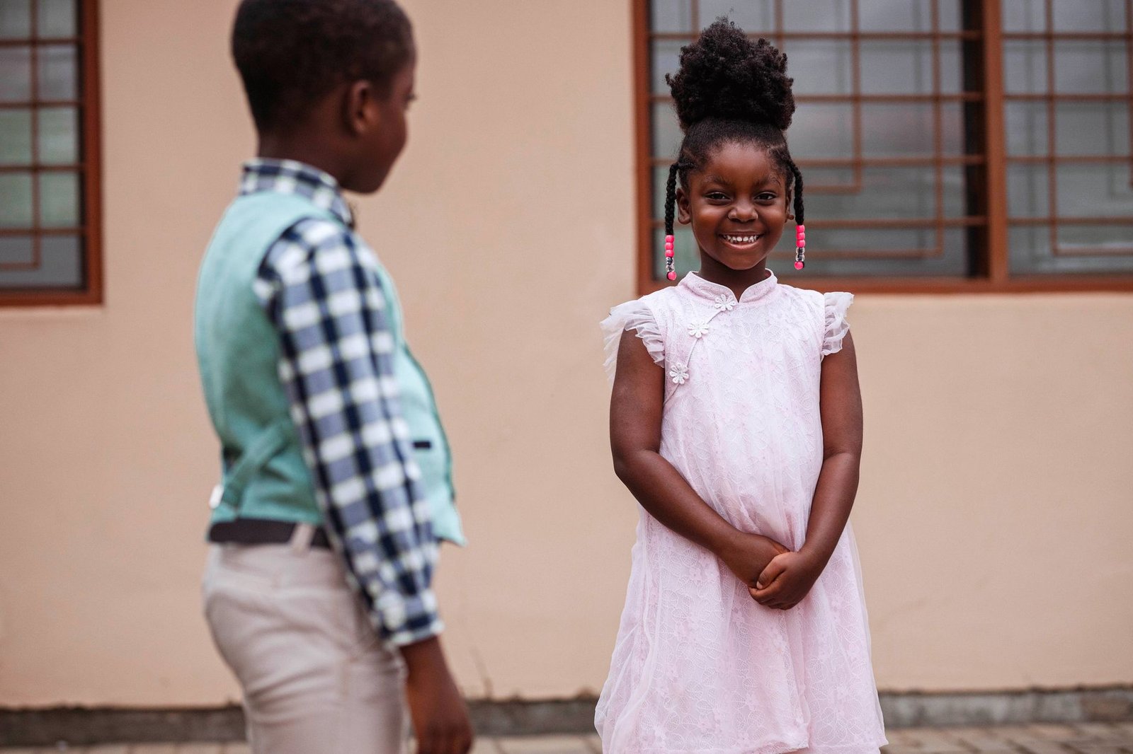 Charming portrait of two children in Accra, Ghana, showcasing joyful expressions and colorful attire.