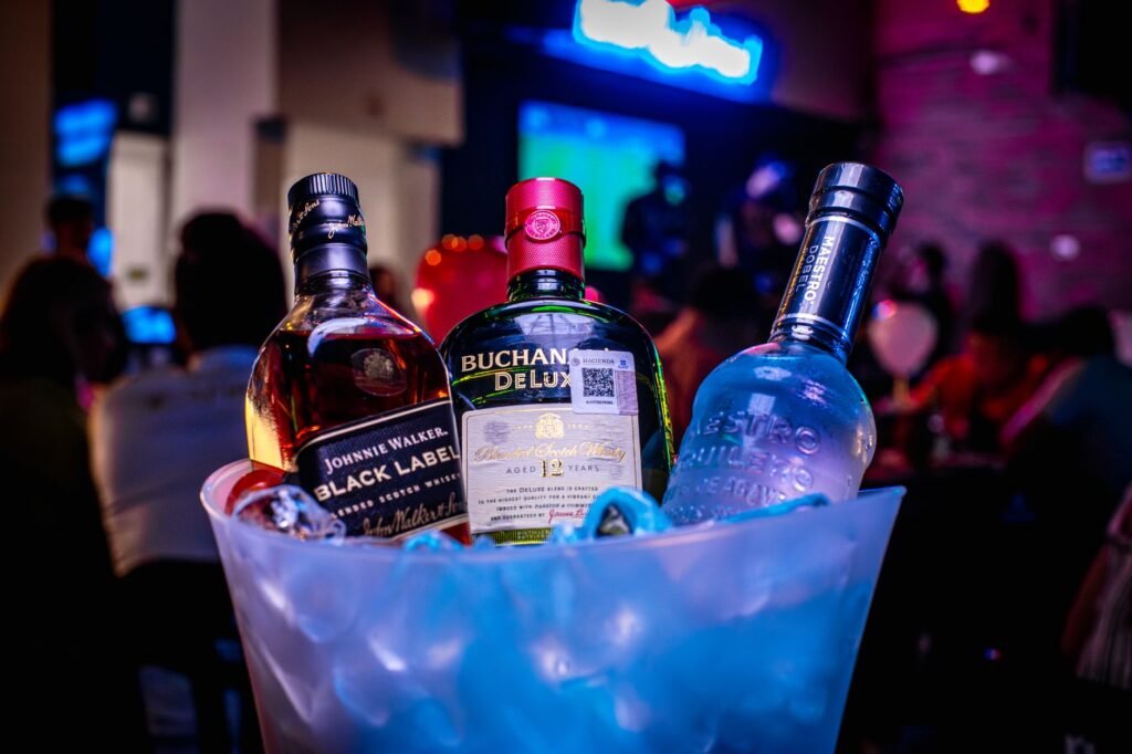 Colorful display of liquor bottles in a vibrant bar setting, creating a lively nightlife atmosphere.