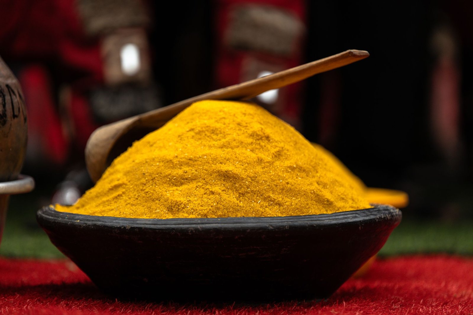 Vivid yellow spice on a wooden plate, symbolizing Ghanaian culinary tradition and cultural richness.