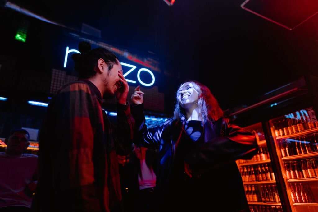 Young couple enjoying a night out at a bustling nightclub, immersed in the vibrant nightlife atmosphere.
