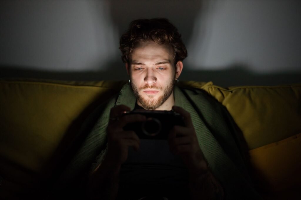Person browsing on a smartphone in a warmly lit room in the evening
