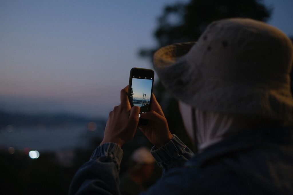Person using a smartphone outdoors at dusk in northern Ghana