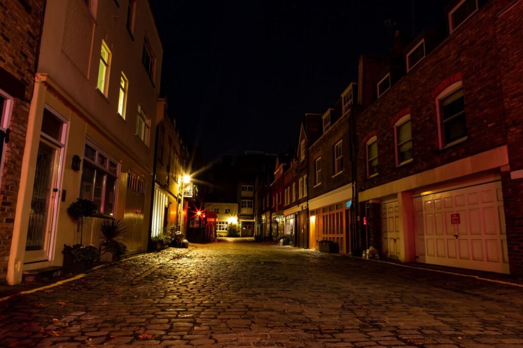 Quiet Ghanaian town street late at night under warm lights