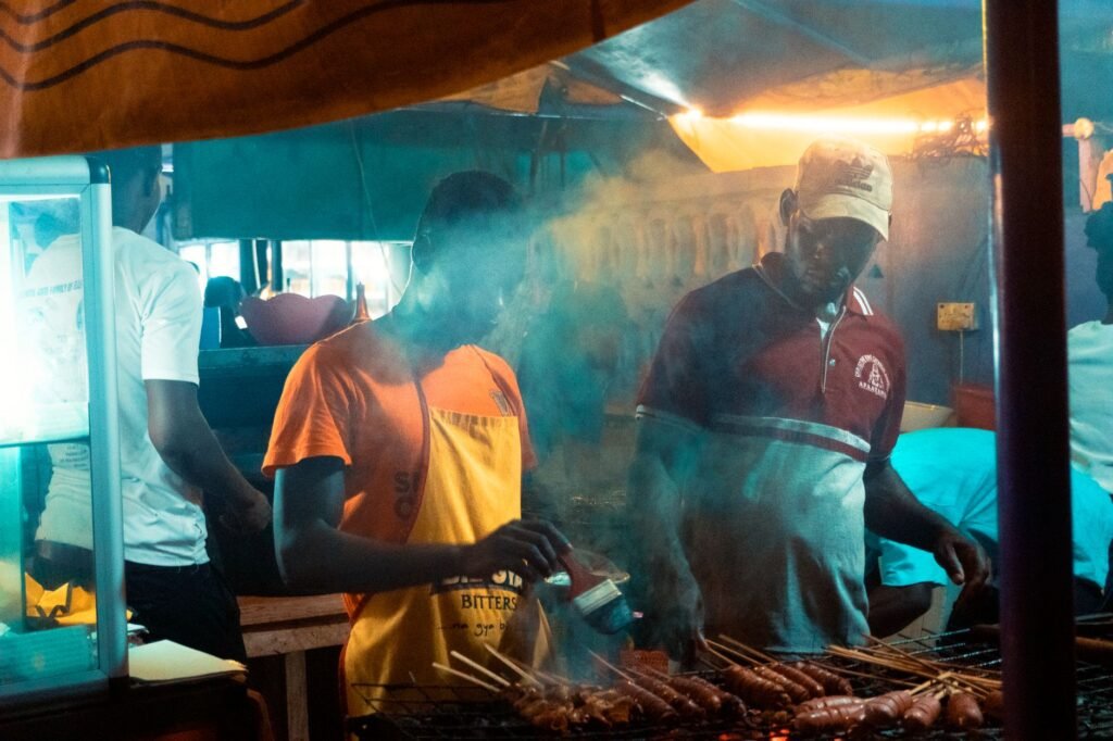 Small evening food stall in northern Ghana lit by warm lanterns