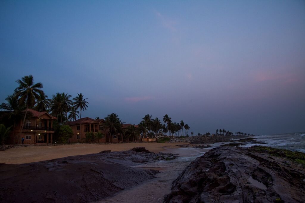 Coastal road at twilight with city lights, illustrating the Tema to Accra evening corridor