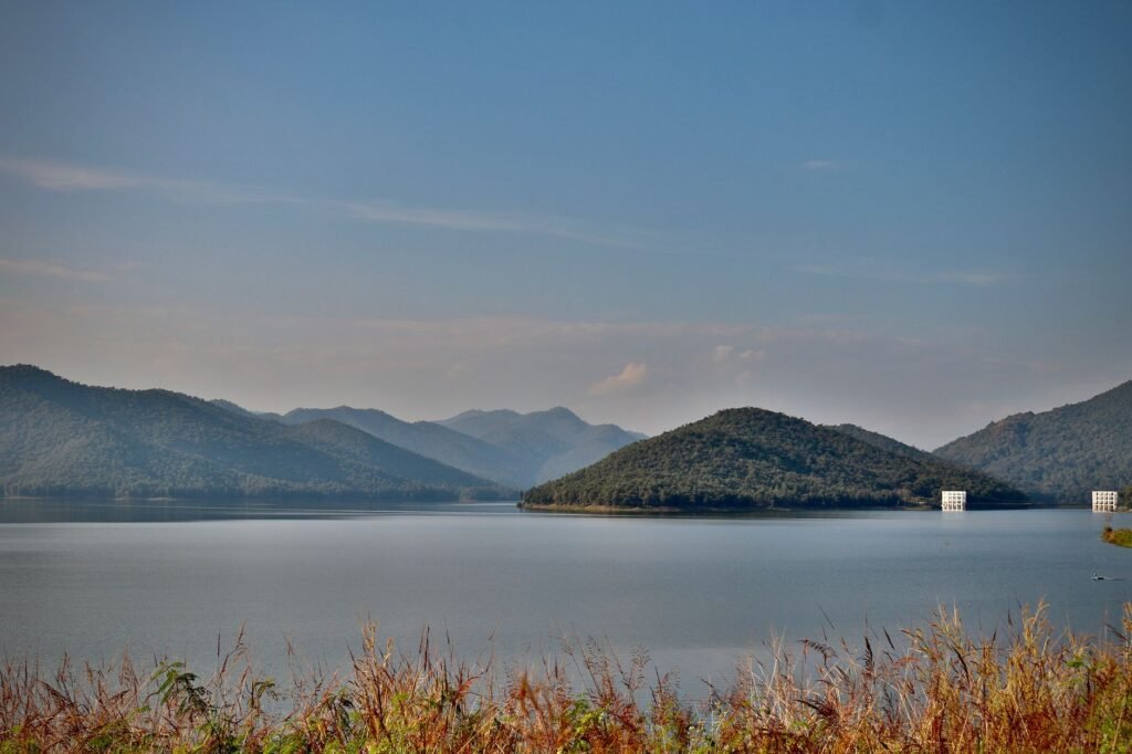 Peaceful landscape showcasing a tranquil lake surrounded by mountains under a clear blue sky.