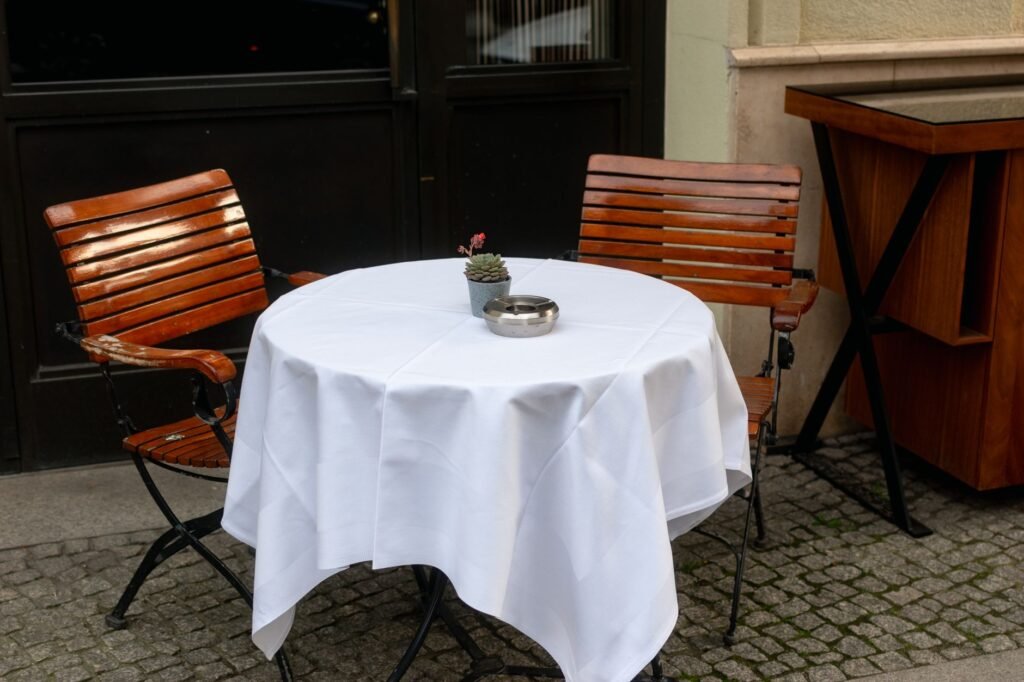 Simple table set for two in a warm-lit Ghanaian cafe with drinks and small plates
