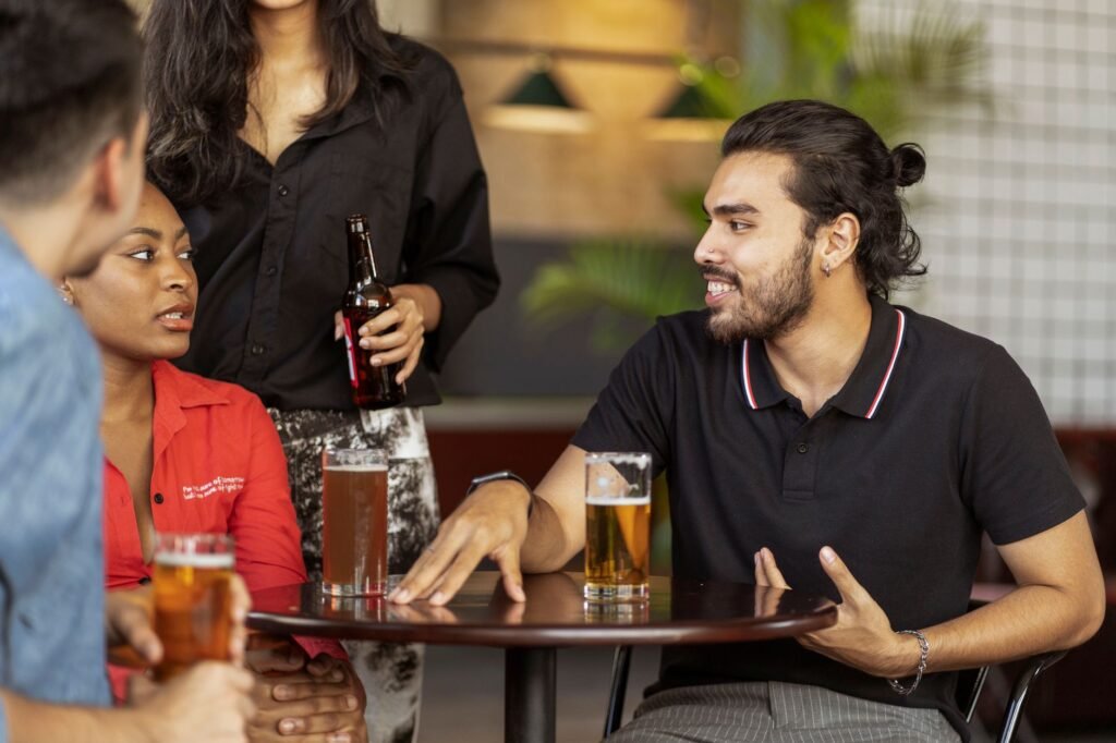 Two people having a relaxed conversation over drinks at a simple table
