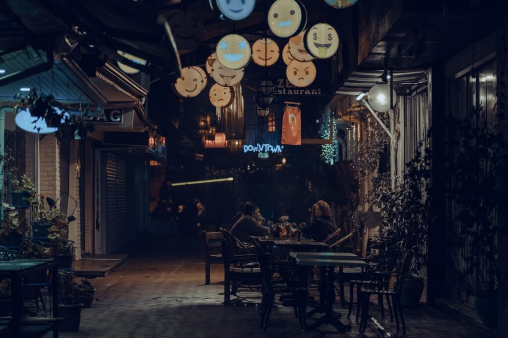Two people having a calm evening conversation at a small outdoor table with drinks