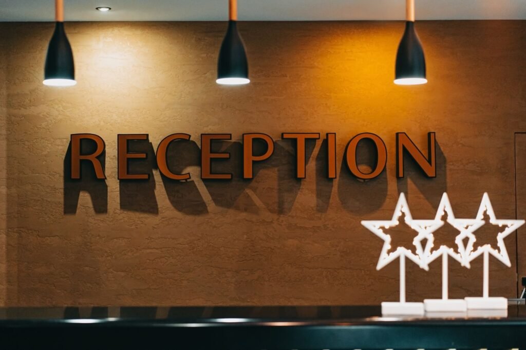 A modest hotel reception desk in a small Ghanaian town with a key rack