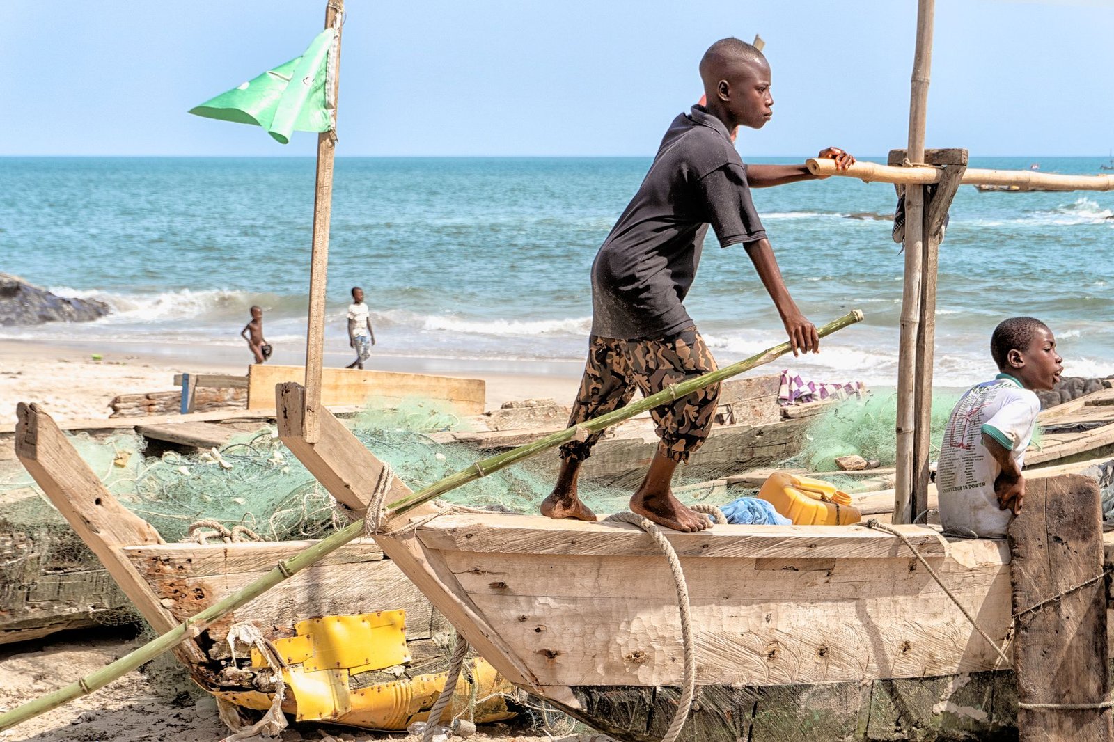 Quiet coastal shoreline in Ghana's Western Region at golden hour with a fishing boat