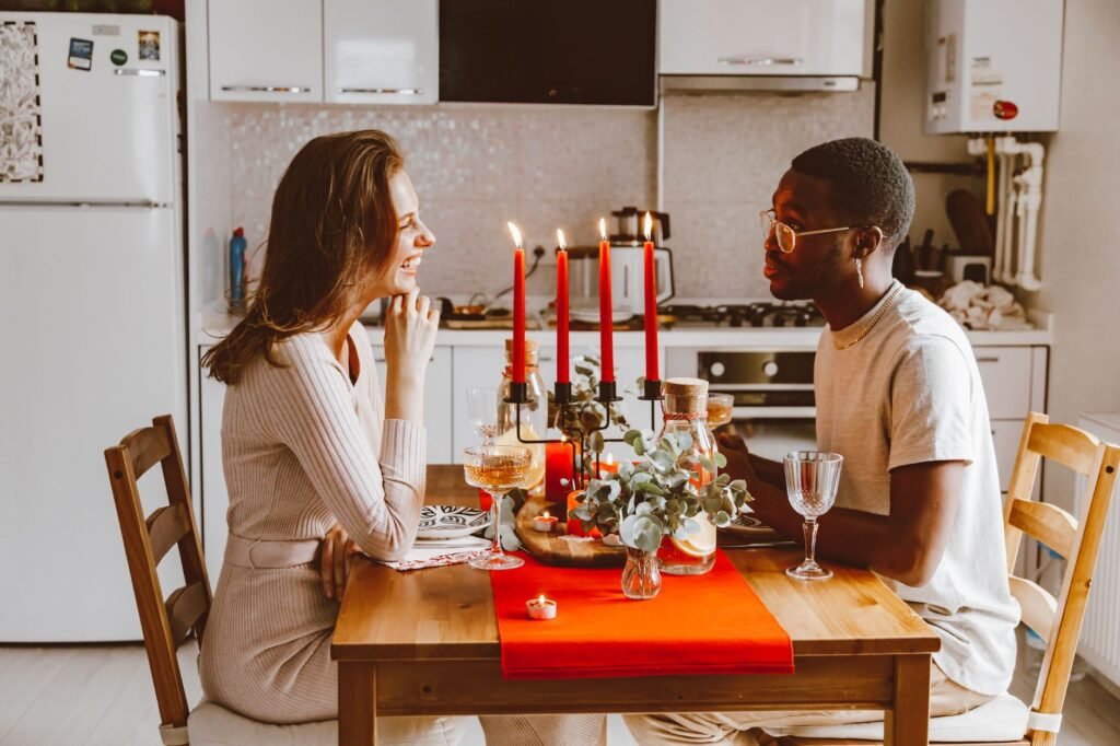 Two adults in relaxed conversation at a table indoors in the evening