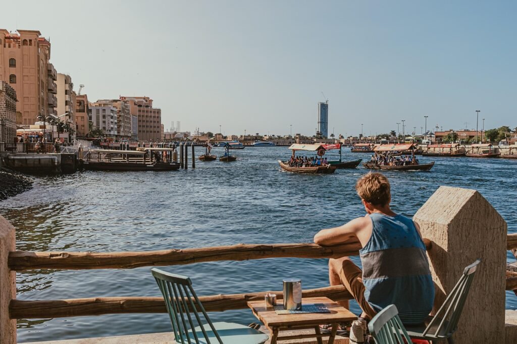 dubai creek, waterfront, man sitting, abra boats, traditional boats, nature, dubai water taxis, relaxing view, outdoor seatin