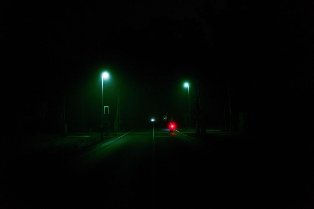 Moody Berlin street scene at night with illuminated street lamps creating an eerie atmosphere.