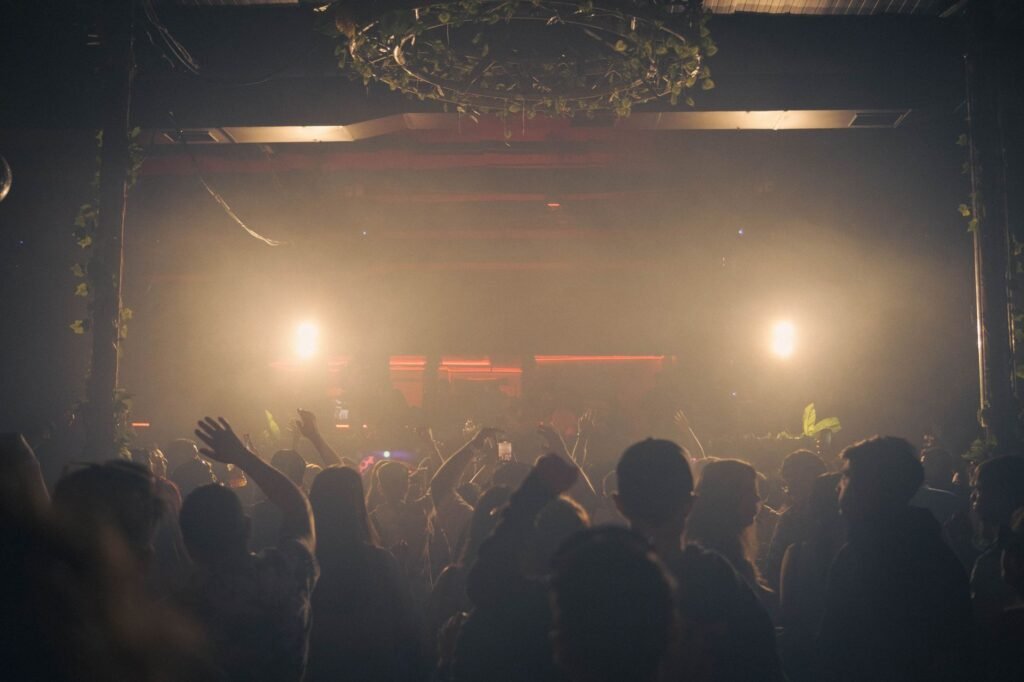 Dynamic nightclub scene with crowd enjoying music under bright lights, creating a lively atmosphere.