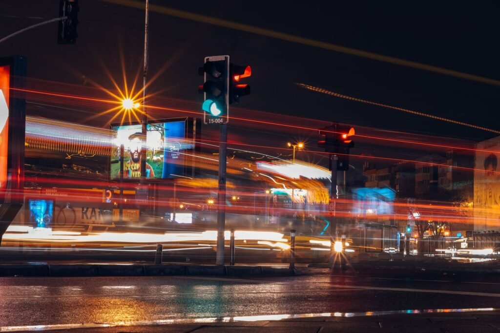 Vibrant city street scene captured with long exposure at night, showcasing motion and lights.