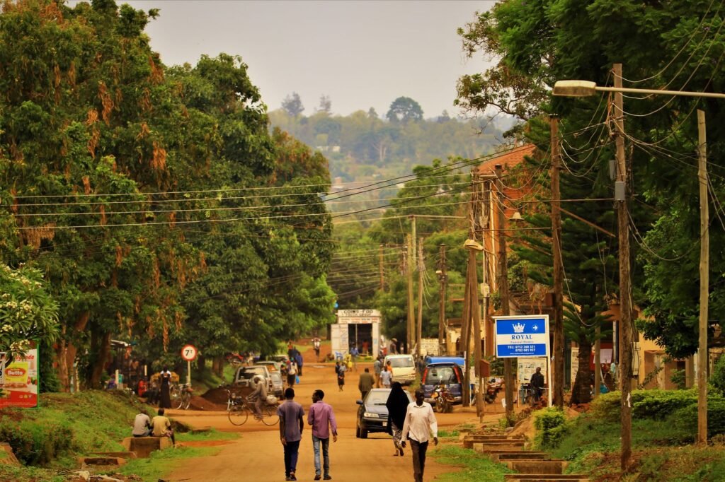 A vibrant street scene capturing daily life in Uganda with people and vehicles.