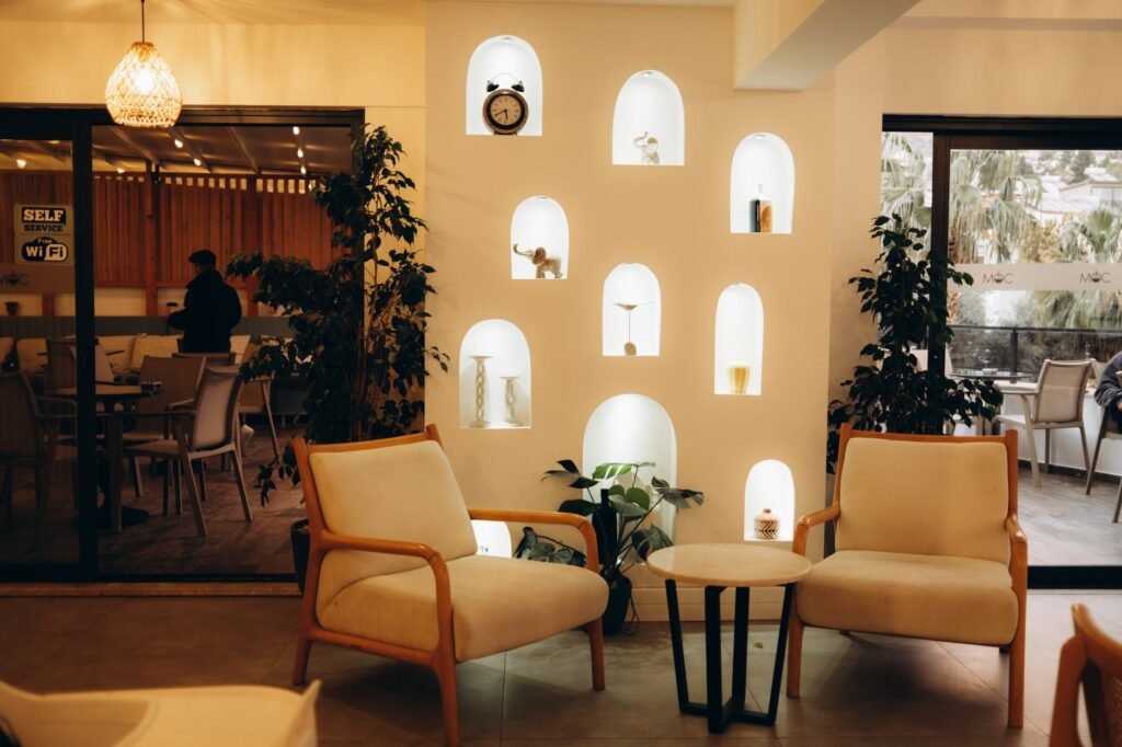 A stylish indoor cafe with modern decor, featuring comfortable seating and illuminated niches.