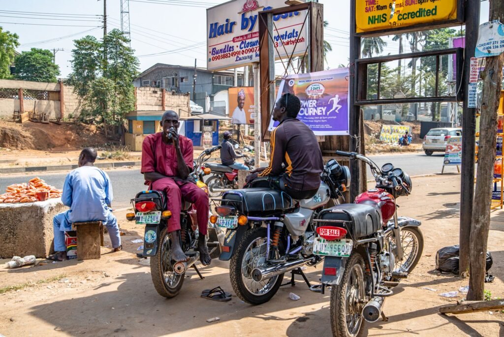 Shared taxi and motorbike taxi at a roadside stop in a Ghanaian coastal town