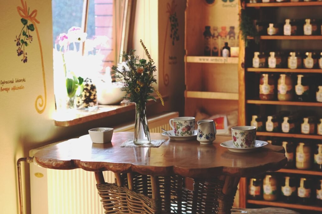 Two cups on a table by a window in a simple guesthouse room