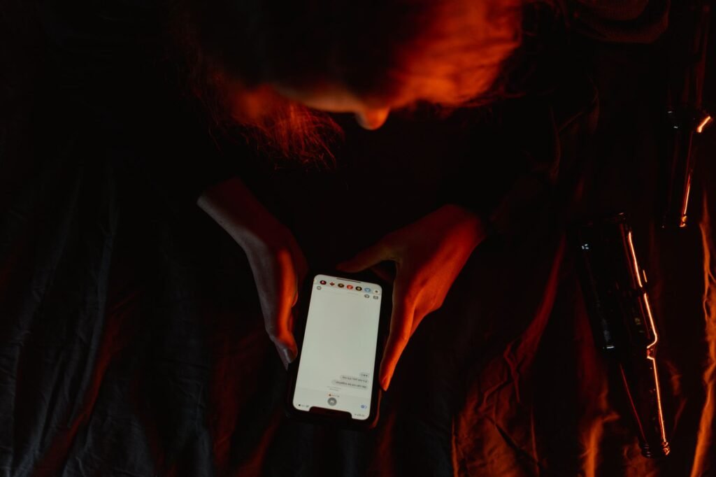 Person checking a phone by a window in a modest hotel room