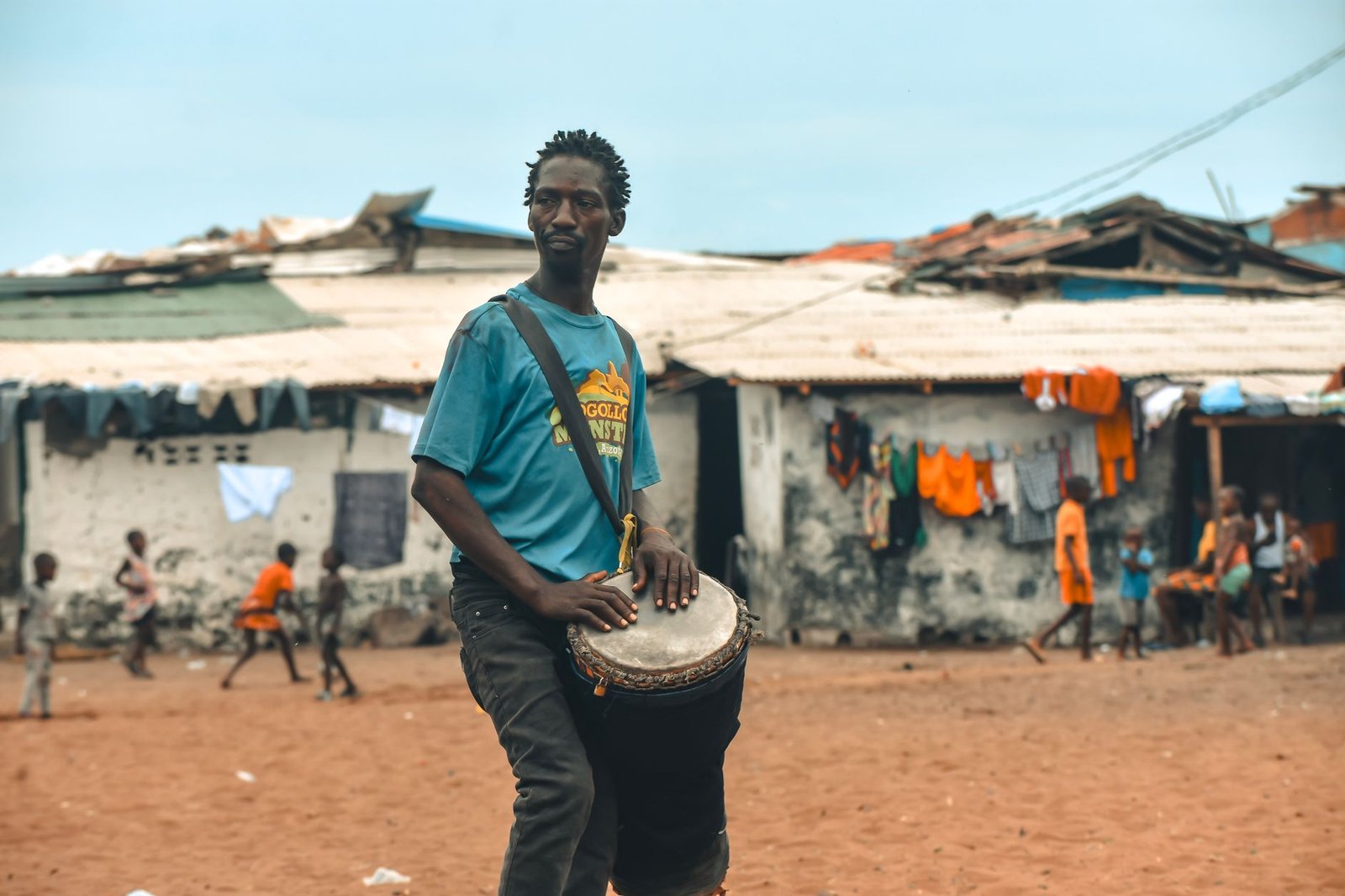 Local musician playing a drum in a lively street scene in Monrovia, Liberia.