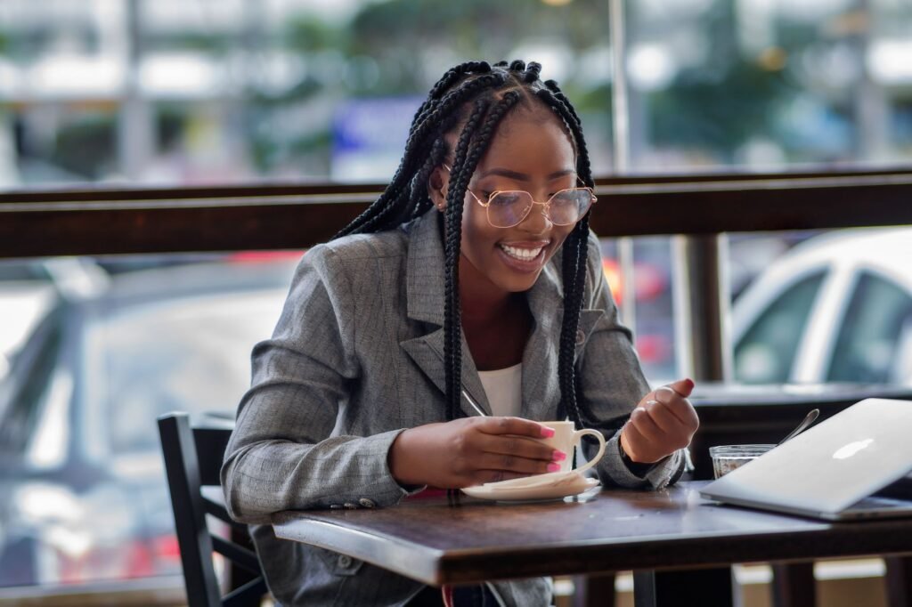 Two people in relaxed conversation at a small table in a Ghanaian cafe