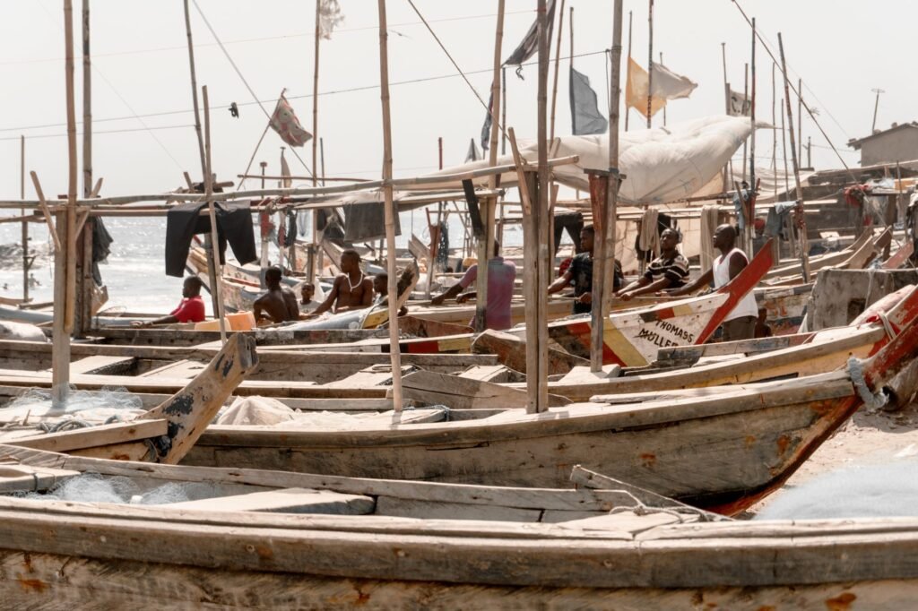 Traditional fishing boats lined up on Elmina beach in Ghana, showcasing local maritime culture.