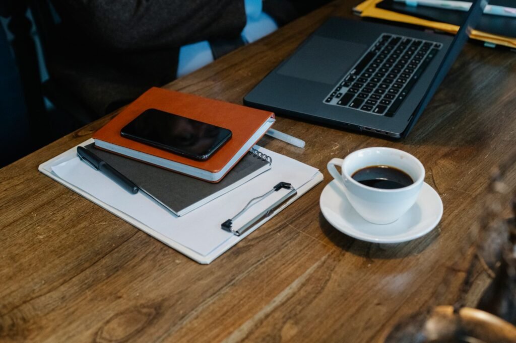 Smartphone and notebook on a wooden table in soft daylight