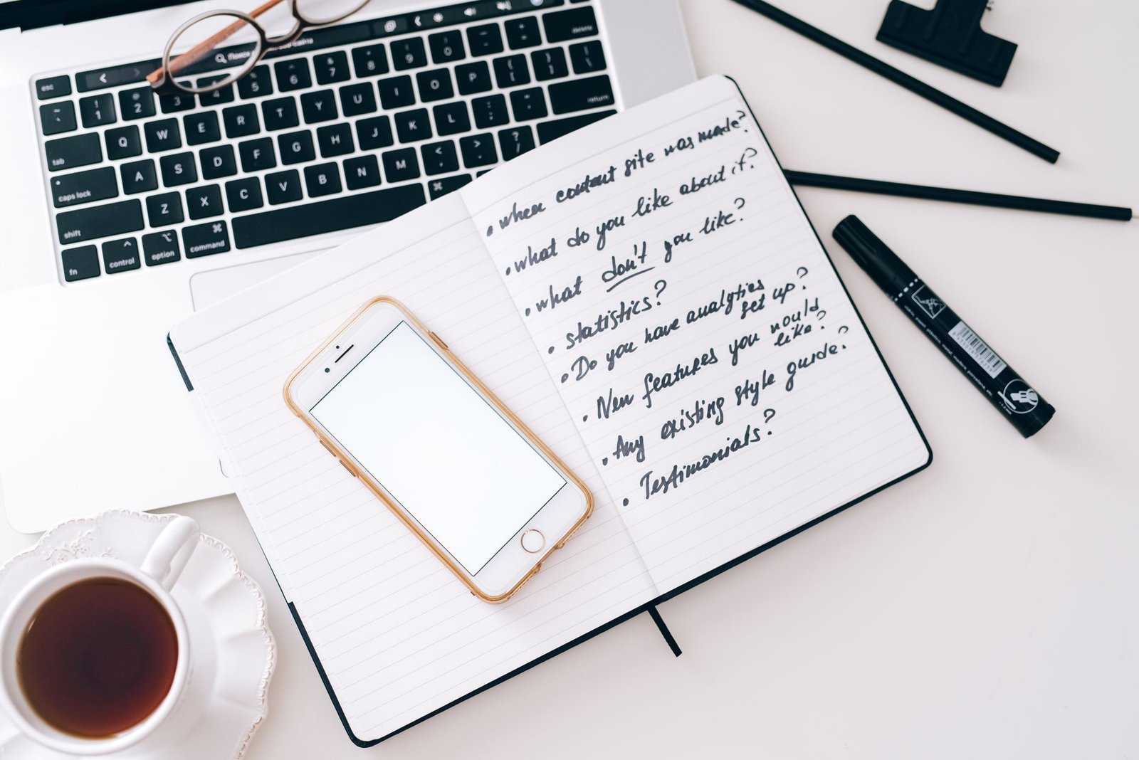 Notebook, smartphone and coffee on a desk used for planning an appointment in Accra
