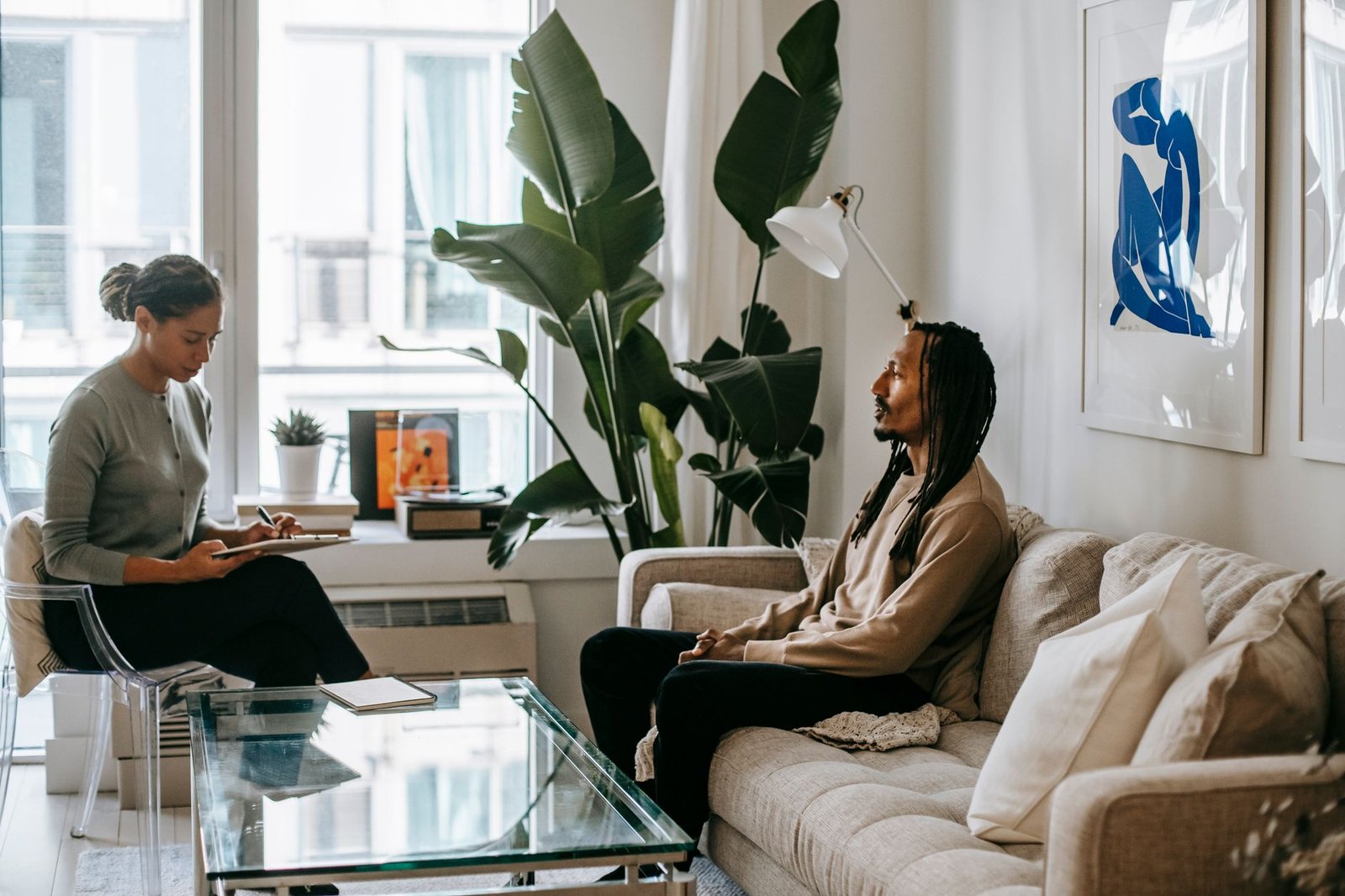 Two adults in a calm conversation indoors, representing respectful booking communication in Adeiso
