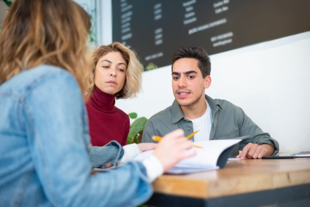 Two adults discussing booking details discreetly