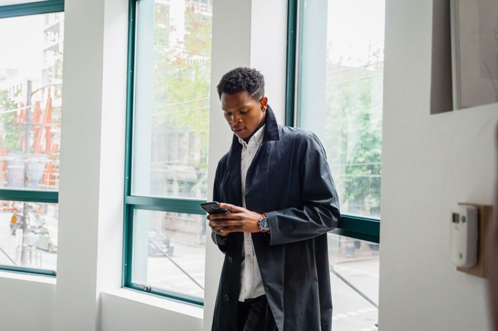 Man sending a polite confirmation message on his phone before a booking in Somanya