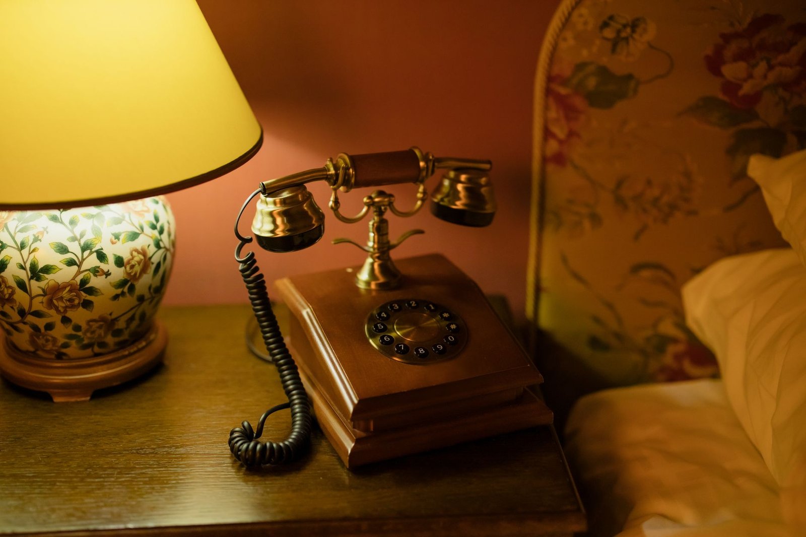 Smartphone and notebook on a bedside table in a softly lit hotel room