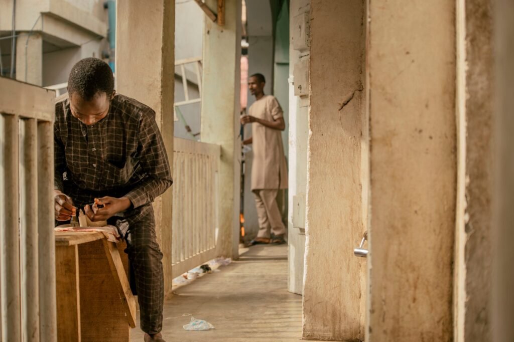 Two people in quiet evening conversation on an outdoor terrace in a coastal West African town