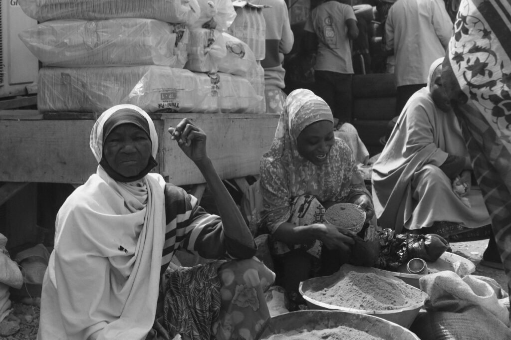 Black and white image of women selling products at a market in Kaduna, Nigeria.