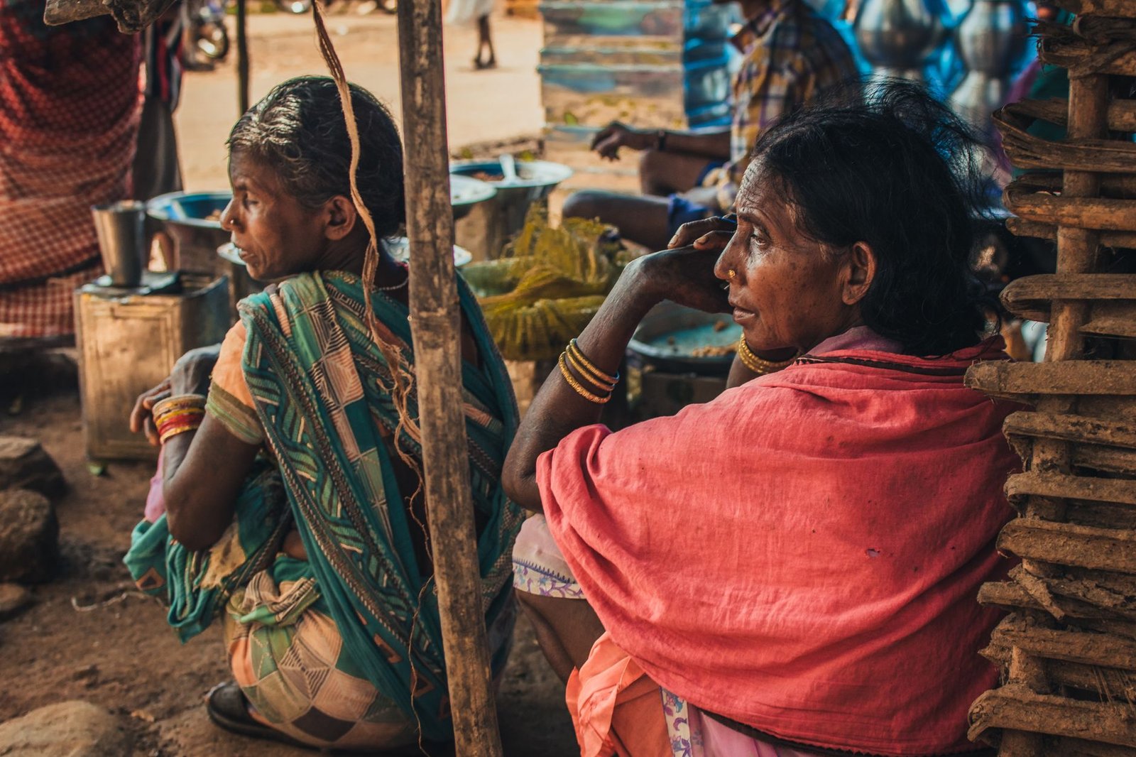 South Asian women at a vibrant market in Bhawanipatna, India, highlighting local culture and commerce.