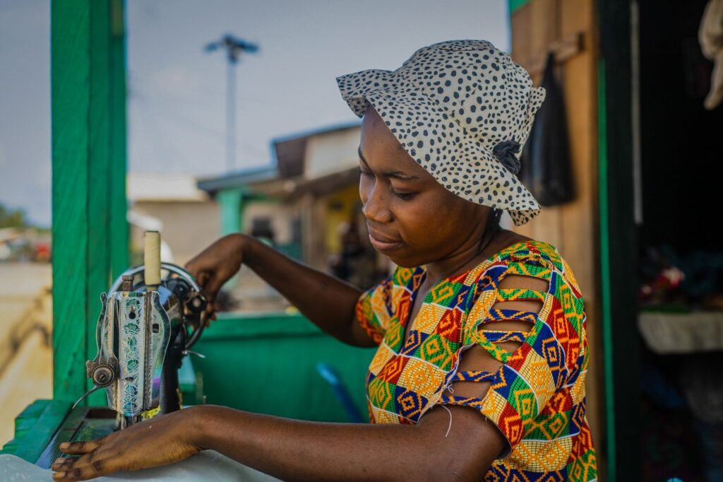 A woman sewing with a vintage machine in Takoradi, Ghana, showcasing local craftsmanship.