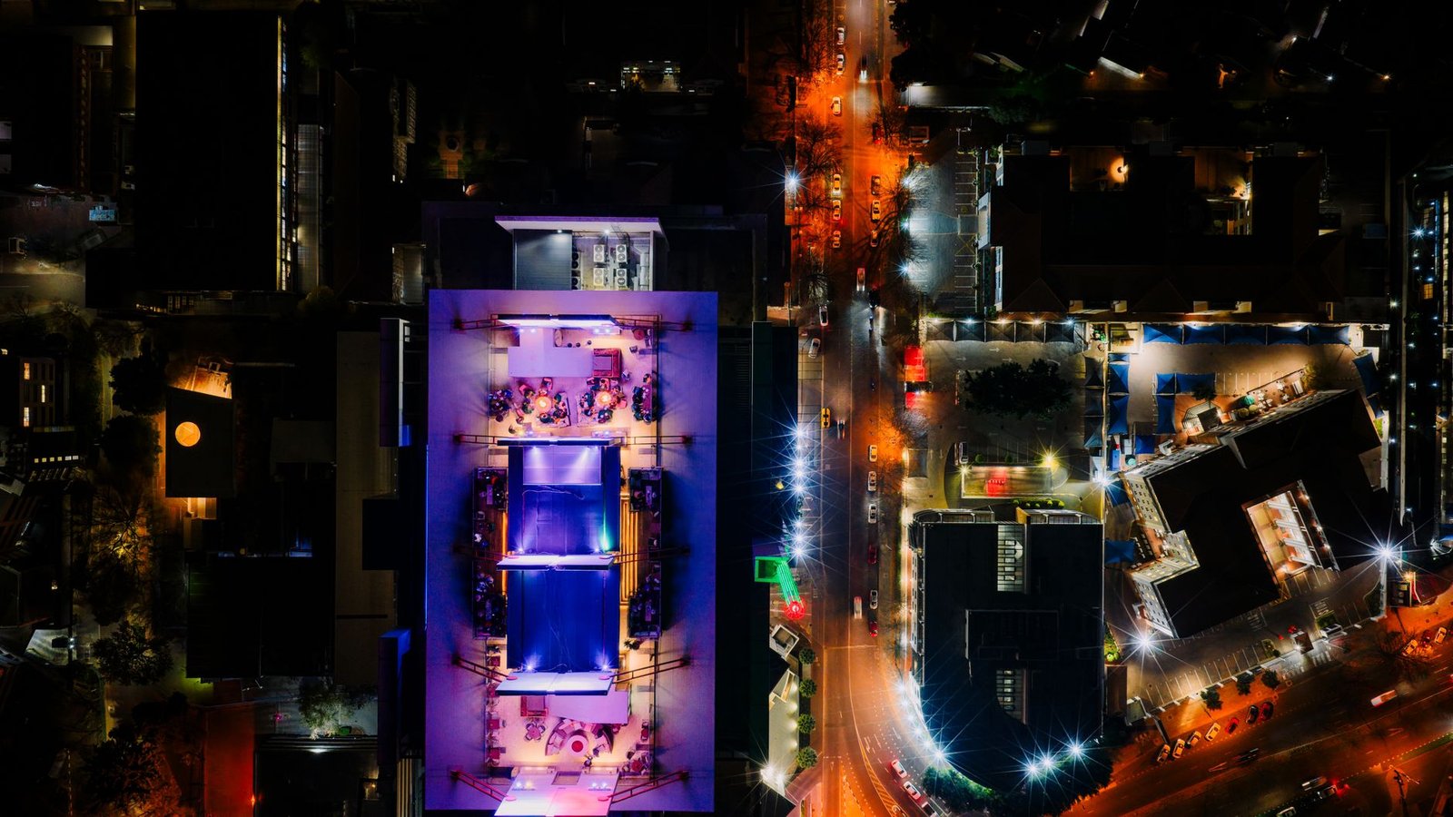 Vibrant aerial night view of Sandton showcasing illuminated rooftops and streets in South Africa.