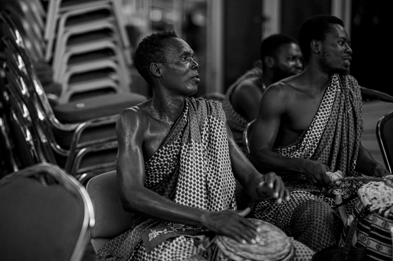 Men in traditional attire drumming at a cultural event in Accra, Ghana.