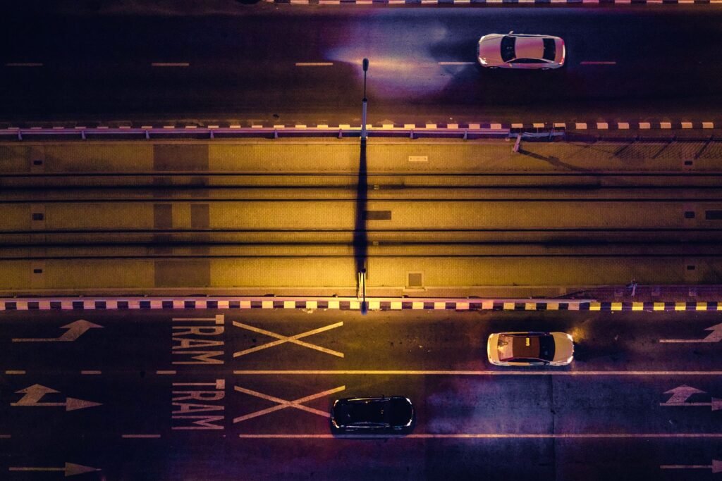 High-angle shot of a Dubai tram line with moving cars at night, showcasing urban transportation.
