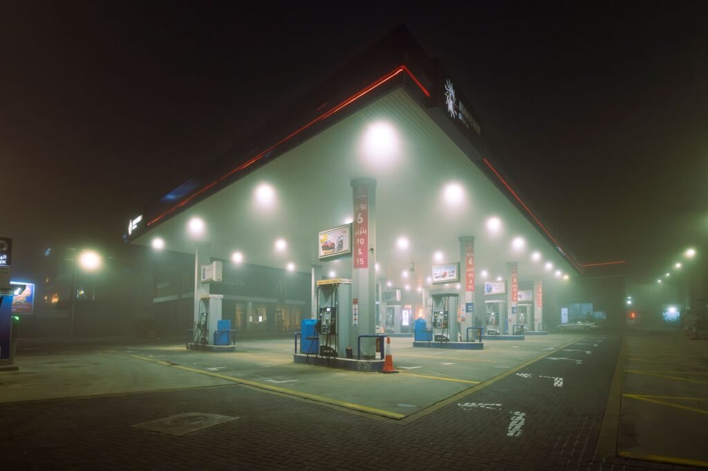 A foggy night scene at an illuminated gas station in Jordan, showcasing a mysterious and quiet atmosphere.