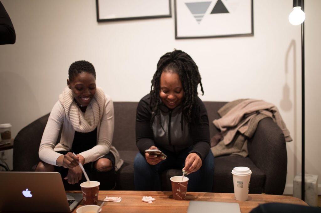 Two women enjoying coffee and a casual meeting in a cozy office setting.