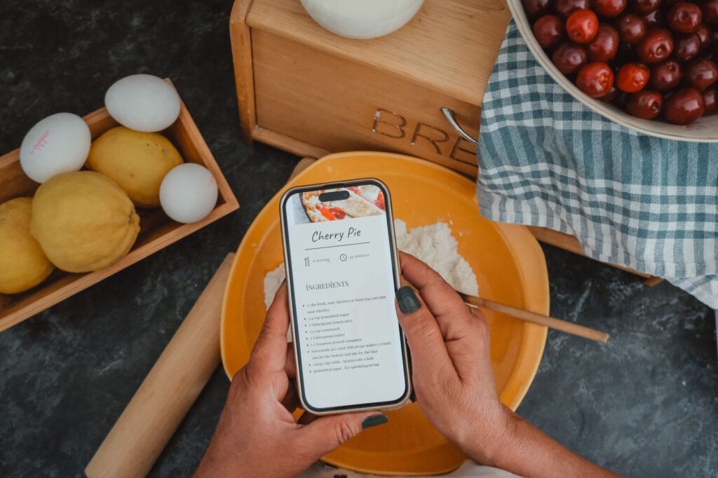 Hands holding a smartphone while browsing a list of profiles at a table