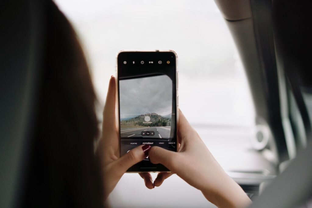 Person using a smartphone to browse listings in daylight